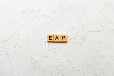 EAP word written on wood block. employee assistance program text on table, concept.