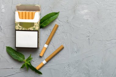 Pack of menthol cigarettes and fresh mint on colored table, Menthol cigarettes top view flat lay. clipart