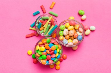 farklı renkte yuvarlak şekerler ve kavanozlar. Fotokopi alanı olan büyük çeşitlilikteki şeker ve şekerlerin üst görünümü.