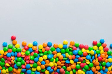 Renkli arka planda karışık renkli şeker koleksiyonu. Düz yerde, üst tarafta. Renkli çikolata kaplı şeker çerçevesi.