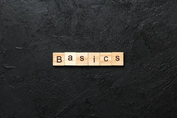 Tahta bloğa yazılmış BASICS kelimesi. Tablo üzerinde BASICS metin, konsept.