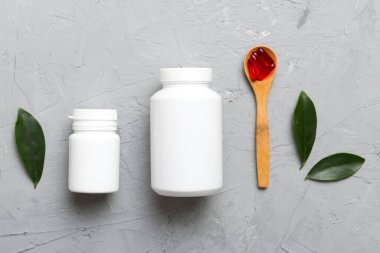 farklı ilaçlar ve ilaç şişesi sağlık hizmeti ve tıbbi destek hapları. Vitamin hapları. Masa arkasında renkli haplar olan bir şişe. Multivitaminler.