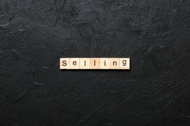 Tahta blokta yazılı kelimeleri satıyorum. Tablo, konsept üzerinde metin satmak.