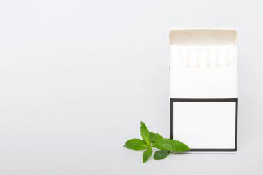 Bir paket mentollü sigara ve renkli masada taze nane şekeri, mentollü sigaralar düz yerde yatıyordu..