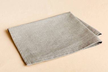 top view with gray kitchen napkin isolated on table background. Folded cloth for mockup with copy space, Flat lay. Minimal style.