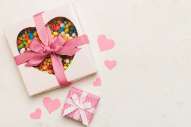 Valentine day composition: sweet candy, with gift boxes with bow and red felt hearts, photo template, background. Top View with copy space.