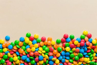 Renkli arka planda karışık renkli şeker koleksiyonu. Düz yerde, üst tarafta. Renkli çikolata kaplı şeker çerçevesi.