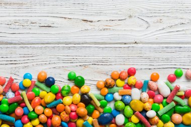 Renkli arka planda karışık renkli şeker koleksiyonu. Düz yerde, üst tarafta. Renkli çikolata kaplı şeker çerçevesi.