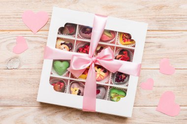 Valentine day composition: sweet candy, with gift boxes with bow and red felt hearts, photo template, background. Top View with copy space.