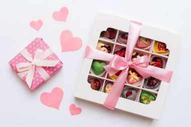 Valentine day composition: sweet candy, with gift boxes with bow and red felt hearts, photo template, background. Top View with copy space.