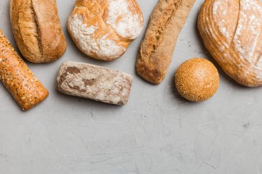Ev yapımı doğal ekmek. Arka plan olarak farklı taze ekmek türleri, kopya alanı ile üst görünüm.