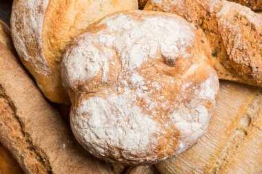 Ev yapımı doğal ekmek. Arka plan olarak farklı taze ekmek türleri, kopya alanı ile üst görünüm.