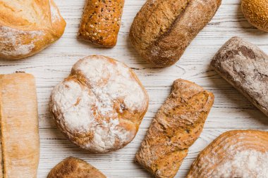 Ev yapımı doğal ekmek. Arka plan olarak farklı taze ekmek türleri, kopya alanı ile üst görünüm.