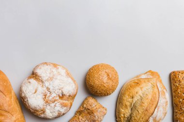 Ev yapımı doğal ekmek. Arka plan olarak farklı taze ekmek türleri, kopya alanı ile üst görünüm.