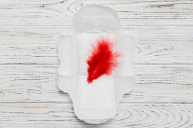 Kadın hijyen ürünleri ya da arka planda kırmızı tüy olan hijyenik ped. Pastel renk. - Yakın çekim. Mesaj için boş bir yer. Kadın günlük hijyeni..