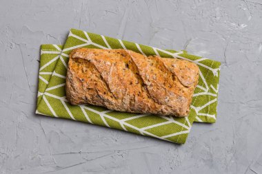 Renkli bir masada buğday ve glüten ile taze somunlar. Peçetedeki ekmek kırsal arka planda, taze ekmek üst görünümü.