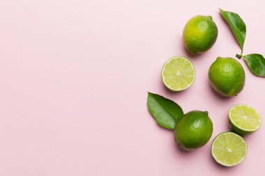 Yeşil yapraklı kireç meyveleri ve beyaz arka planda yarım dilim kesilmiş. Üst Manzara. Kopyalama alanı olan düz.