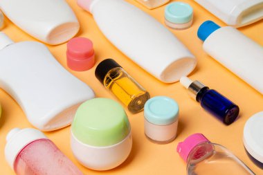 Plastik gövde bakımı şişesi düz kompozisyonu ve renkli arka plan boşluğuna kozmetik ürünler dizayn edilmişti. Beyaz Kozmetik kapları kümesi, kopya alanı ile üst görünüm.