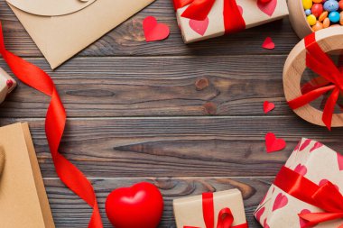 top view photo of st valentine day decor shopping, bag, envelope, gift, box, candy and red heart on colored background with empty space. Frame background.