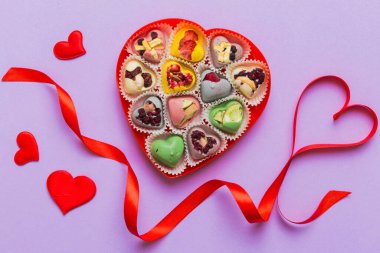 Valentine day composition: sweet candy, with gift boxes with bow and red felt hearts, photo template, background. Top View with copy space.