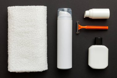 Tıraş Adam seti. Traş makinesi, havlu, losyon ve renkli arka planda tıraş köpüğü. Erkekler banyo aksesuarları üst görünüm.