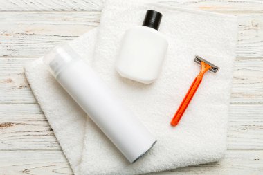 Tıraş Adam seti. Traş makinesi, havlu, losyon ve renkli arka planda tıraş köpüğü. Erkekler banyo aksesuarları üst görünüm.