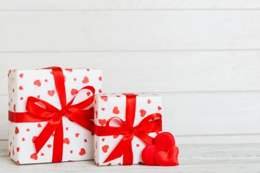 gift box with red bow and red heart on colored background. Perspective view. Flat lay.