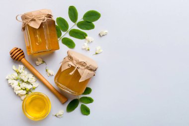 Akasya çiçekli ve yapraklı bal kavanozu. Taze bal üst görünüm düz yatıyordu.