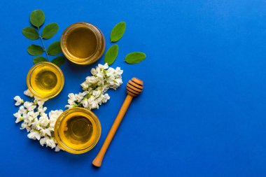 Akasya çiçekli ve yapraklı bal kavanozu. Taze bal üst görünüm düz yatıyordu.