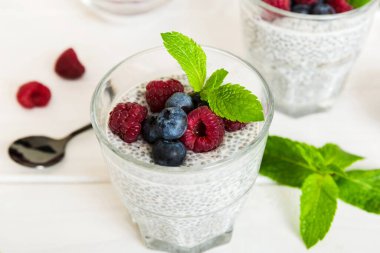 Sağlıklı kahvaltı ya da sabah chia tohumlu vanilyalı puding ahududu ve böğürtlen, vejetaryen gıda, diyet ve sağlık konsepti. Ahududu ve yabanmersinli Chia pudingi..