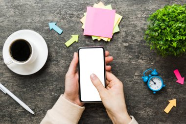 Mesajınız veya bilgi içeriğiniz için boş bir kopya ekranı olan akıllı telefonları tutan kadın ellerinin üst görünümü. üst görünümde telefon beyaz ekranı kullanan kadın eli.