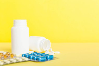 HIV enfeksiyonunun tedavisi için ilaç. Haplar, kapsüller ve masada savaş. Renkli arkaplanda kopyalama alanı olan farklı renkli tabletler.