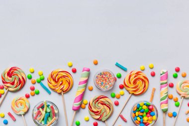 Lezzetli İştah açıcı Parti Aksesuarları Mutlu Yıllar Tatlı. Renkli arkaplanda farklı tipte şekerler, kopyalama alanı. Renkli doğum günü partisi geçmişi.