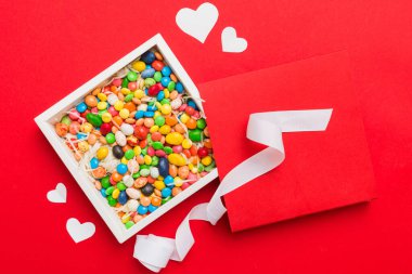 Valentine day composition: sweet candy, with gift boxes with bow and red felt hearts, photo template, background. Top View with copy space.