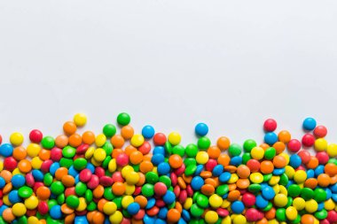 Renkli arka planda karışık renkli şeker koleksiyonu. Düz yerde, üst tarafta. Renkli çikolata kaplı şeker çerçevesi.