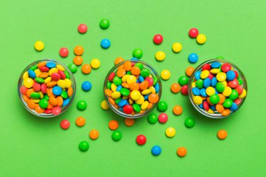 farklı renkte yuvarlak şekerler ve kavanozlar. Fotokopi alanı olan büyük çeşitlilikteki şeker ve şekerlerin üst görünümü.