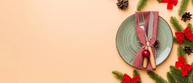 Noel süsleri, tabaklar, inekler, çatallar ve kaşıklarla Noel sofrası. Noel tatili geçmişi. Kopyalama alanı olan üst görünüm.