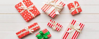 Masada renkli kağıtlarla süslenmiş bir sürü Noel hediyesi kutusu var. Birçok hediye var..