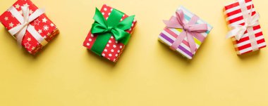 Renkli kağıda sarılı ve renkli arka planda konfetiyle süslenmiş hediye kutularıyla tatil dairesi yatıyordu. Noel, Doğum günü, Sevgililer Günü ve satış konsepti, üst manzara.