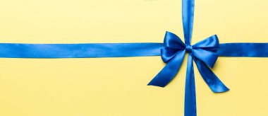 Mor kurdelenin üst görüntüsü yuvarlandı ve pembe fiyonk renkli arka planda izole edildi. Kopyalama alanı olan düz.