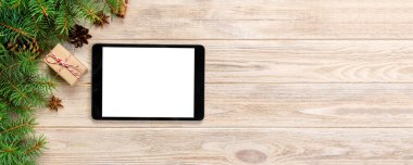 Dijital tablet kadar app tanıtımı için rustik Noel ahşap arka plan süslemeleri ile alay. kopya alanı ile üstten görünüm.