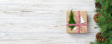 Noel hediye kutusu ile şerit rustik arka plan üzerinde şerit yay ile geri dönüşümlü kağıt sarılı. Tatil kavramı.