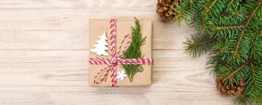 Noel köknar ağacı ve hediye kutusu ahşap masa üzerinde arka plan. Tasarımınız için kopya alanı ile üstten görünüm.