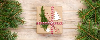 Noel köknar ağacı ve hediye kutusu ahşap masa üzerinde arka plan. Tasarımınız için kopya alanı ile üstten görünüm.