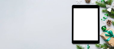 Digital tablet mock up with rustic Christmas decorations for app presentation top view with empty space for you design. Christmas online shopping concept. Tablet with copy space on colored background.
