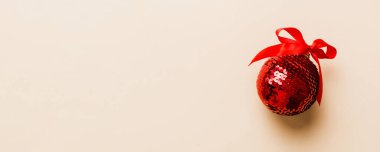 Christmas ball on colored background. decoration bauble with ribbon bow with copy space.