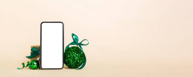 Digital phone mock up with rustic Christmas decorations for app presentation with empty space for you design. Christmas online shopping concept. Tablet with copy space on colored background.