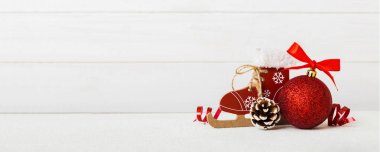 Christmas ball with skates on colored background. decoration bauble with ribbon bow with copy space.