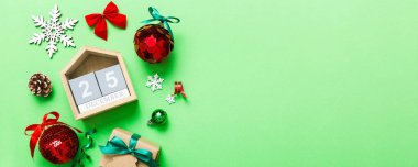 Christmas calendar 25 december. Christmas gift, fir branches, pine cones. Flat lay, top view. New Year decorations on a colored background.