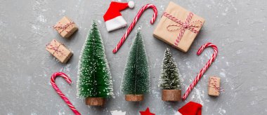 Renkli arka planda noel ağaçları olan düz kompozisyon. Kopyalama alanı olan üst görünüm.